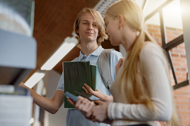 两个朋友的学生站在大学图书馆选书图片下载