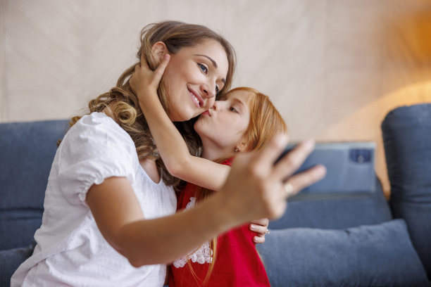 女儿在家自拍时亲吻母亲图片下载