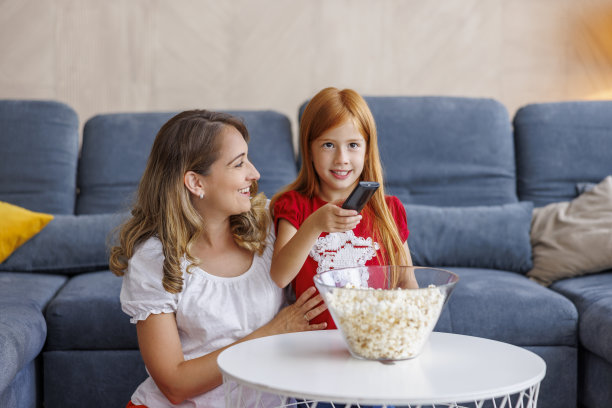母女俩在家看电视，吃爆米花图片下载