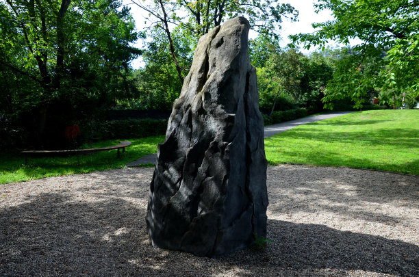 经过表面处理的攀岩训练用毛毡石。城市公园里的牙齿形状的巨石。儿童游乐场上的成人大小的石头仿制品。有裂缝和握把图片下载