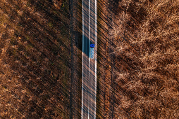航拍的牛奶运输水箱卡车在秋天的下午沿着非城市景观行驶，无人机pov图片下载