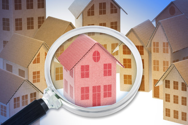 用放大镜观察纸板房子的模型，寻找新的家居概念图片下载