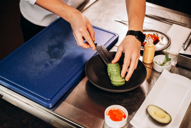 厨师用刀在砧板上切牛油果。健康的水果和食物饮食理念。特写照片图片下载