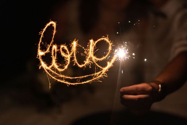 一场婚礼在夜晚手持“爱”的烟火庆祝的特写镜头图片下载