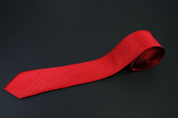 红色领带卷在黑色的背景图片下载
