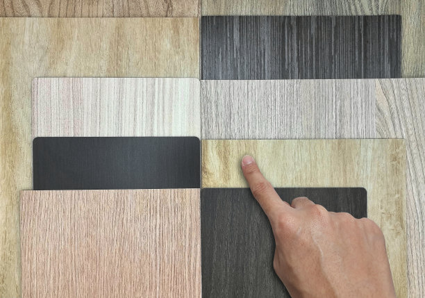 设计师亲手选择各种类型和纹理的室内木质材料，包括胡桃木单板，灰层压，橡木乙烯基地板样品。木材的多重纹理用作背景。图片下载