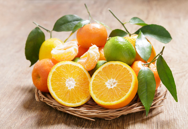 木桌上放着新鲜的柑橘类水果和叶子图片下载