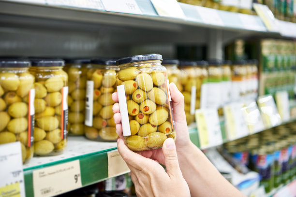 橄榄罐头在商店买主手中图片下载