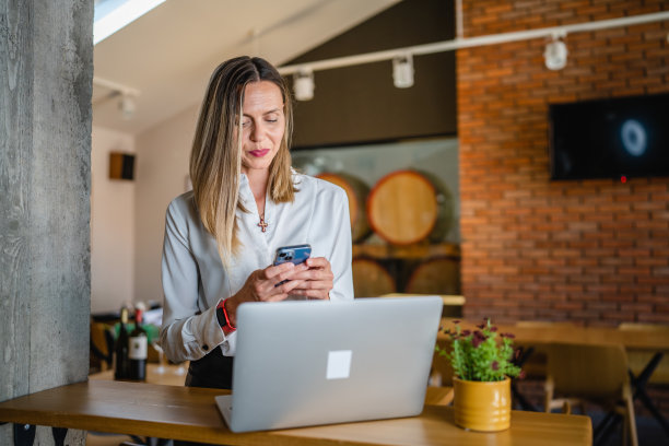 一名白人女性成年企业家在工作时使用手机图片下载