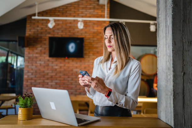 一名白人女性成年企业家在工作时使用手机图片下载