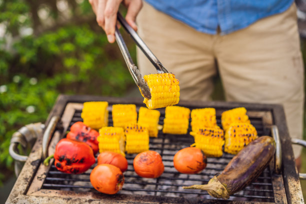 一个男人用火钳在后院烧烤图片下载