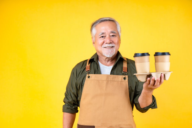 肖像迷人的退休亚洲老人有白色的胡子，戴着围裙和胡子拿着纸杯咖啡图片下载