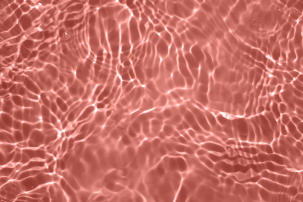 散焦模糊透明粉红色，清澈平静的水面纹理与飞溅和气泡。时髦的抽象自然背景。水波在阳光下复制空间。粉红色的水彩闪亮的图片下载