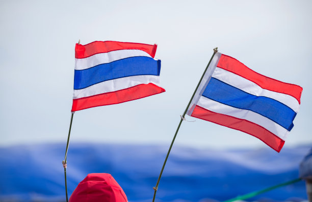 挥舞着白色和蓝色背景的泰国国旗的图片。图片下载