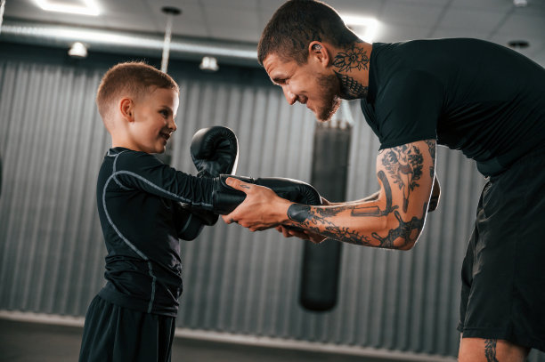 职业运动的开始。教练正在室内教男孩拳击技巧图片下载