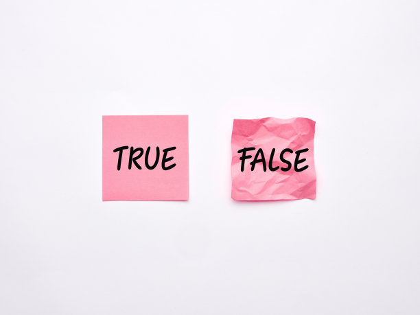 真假两个字写在白色背景的粉色便签纸上。考试或真实信息概念。图片下载