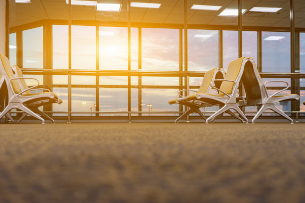 旅客座位在候机室，可以从机场航站楼看到飞机。太阳光线以复古色彩选择性聚焦，交通出行概念图片下载