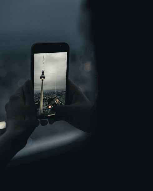 一个人用智能手机拍城市照片的垂直镜头图片下载