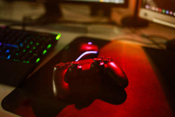 玩家工作空间概念，俯视图一个游戏设备，鼠标，RGB颜色的键盘，操纵杆，耳机，摄像头，VR耳机在黑色的桌子背景图片下载