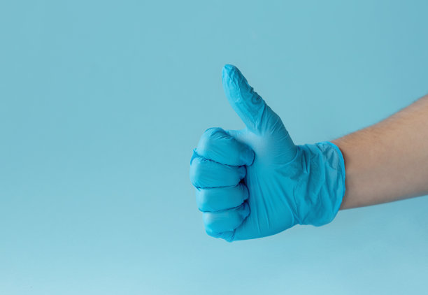 戴上蓝色医用手套，做出ok手势。孤立在蓝色背景上。副本的空间。空白的地方，文字或标志。图片下载
