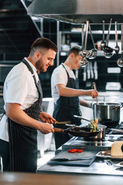 在制服。厨房工作人员正在一起准备食物图片下载