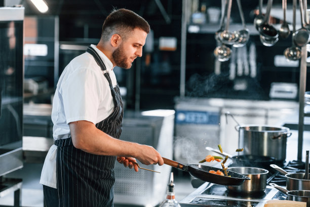 煎锅上的火焰。厨师在厨房准备食物图片下载