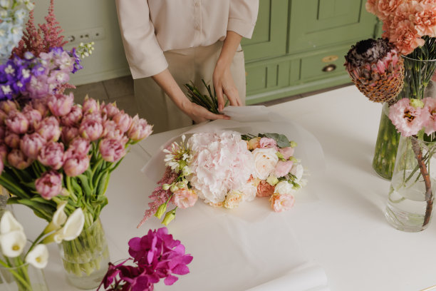 漂亮的女孩在一家花店收集一束花图片下载