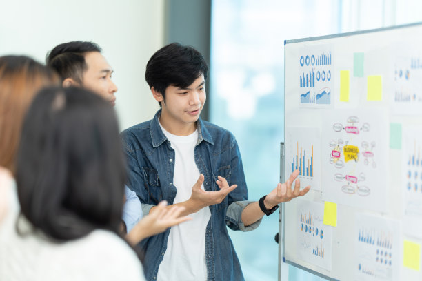 商务人士展示团队合作，同时在董事会会议室在办公室内部工作。帮助同事完成新的商业计划。经营理念。团队合作精神。图片下载