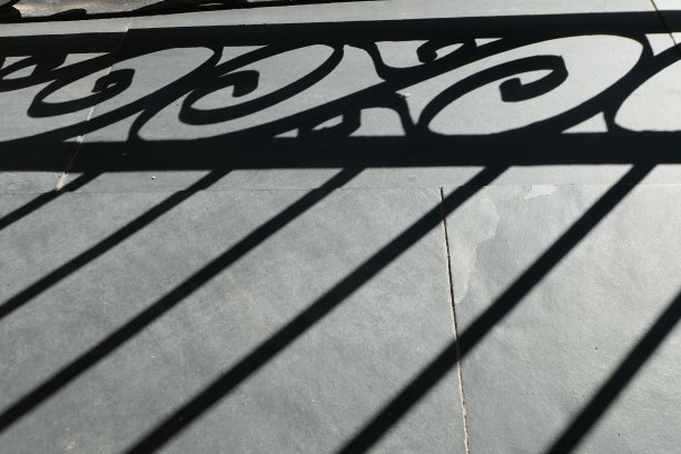 别墅阳台上金属栏杆的单色灰色几何阴影图片下载