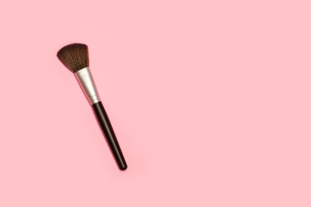 用画笔在带有复制空间的粉色背景上化妆图片下载