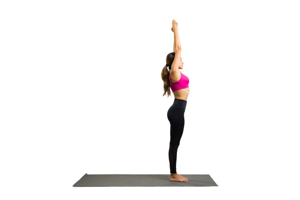 积极的女人放松，同时练习拜日式瑜伽姿势图片下载