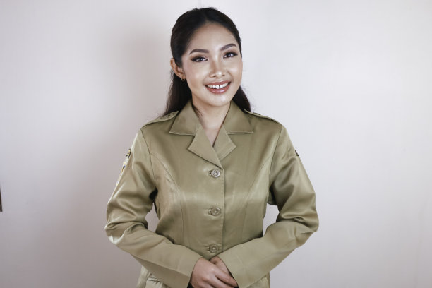 身穿棕色制服的亚洲女性对着镜头微笑的肖像。印尼政府雇员的制服。图片下载