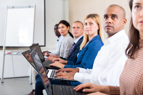 拉丁美洲商人在商务培训期间用笔记本电脑的侧面视图图片下载