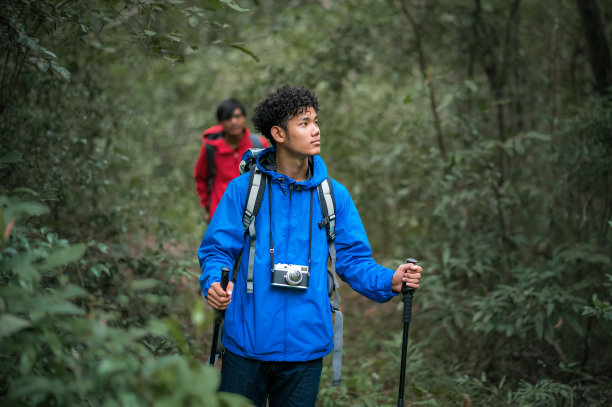 两个年轻的亚洲男性背包客徒步旅行，研究热带森林的自然生态旅游。游客徒步旅行去泰国欣赏热带森林之美。图片下载