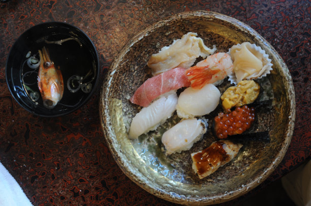 在日本的一家餐厅里，美味的手工手握寿司搭配生鱼和米饭放在盘子里图片下载