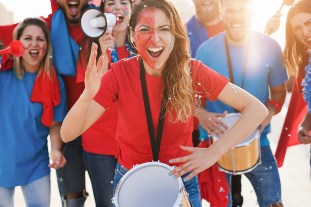 疯狂的体育迷打鼓和尖叫，同时支持他们的球队-关注中心的女孩鼓图片下载
