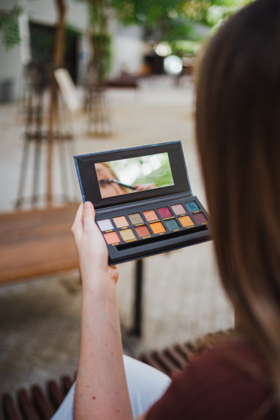 女生在休息时化妆的透视镜头。她在大学校园里。图片下载