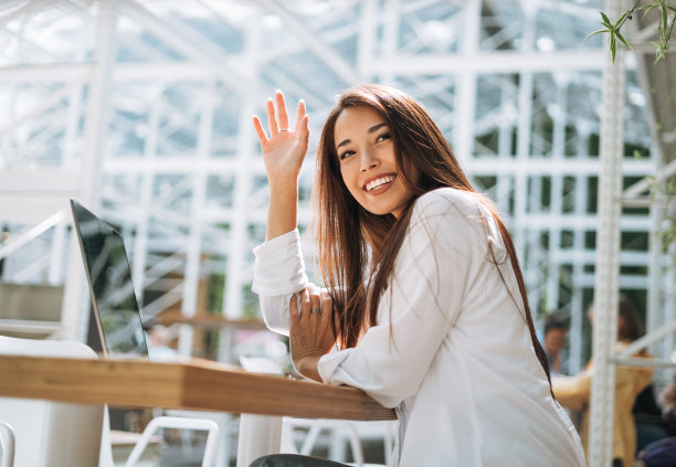 年轻的亚洲女学生自由职业者与长发工作在笔记本电脑会议的朋友在街头咖啡馆图片下载
