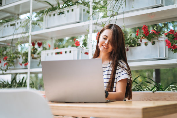 留着长发的年轻女学生自由职业者，在街头咖啡馆用笔记本电脑工作图片下载