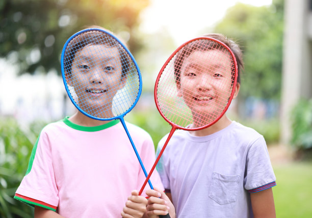 快乐的孩子们在公园里玩羽毛球。图片下载