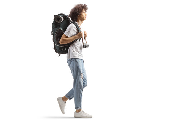 一个年轻男性背包客的完整侧写背着背包和相机走着图片下载