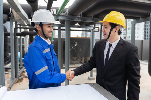 经理拜访在屋顶管架附近工作的工程师，检查进度图片下载