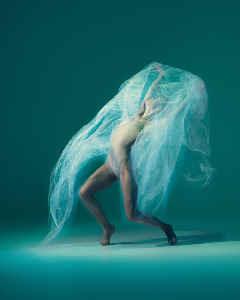 优雅的芭蕾舞者用白色的布料跳舞，布料孤立在绿色的背景上。艺术，运动，行动，灵活，灵感的概念。图片下载