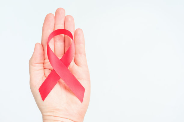 一位女性手握红丝带，这是国际防治艾滋病和艾滋病病毒日。图片下载
