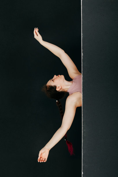 一个漂亮的黑发女孩从黑屏后向外张望。一名年轻女子的肖像工作室用她的手做流畅的动作。美容和修甲的概念。图片下载