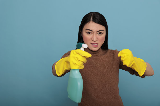 兴奋精力充沛的亚洲年轻管家洗衣液喷雾器站在战斗姿势图片下载