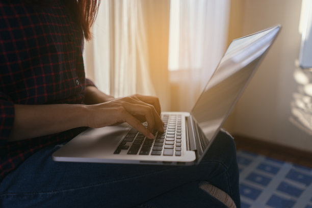 一个女孩在咖啡馆的笔记本电脑工作，女人的手指在键盘上打字。工作地点在一家咖啡馆，她一大早就查看邮箱，一边使用小工具，一边在现代图书馆学习，教育商业图片下载