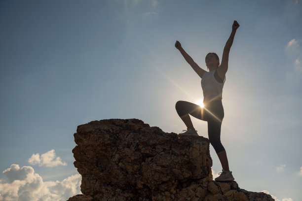 胜利的手势在山顶在日落图片下载