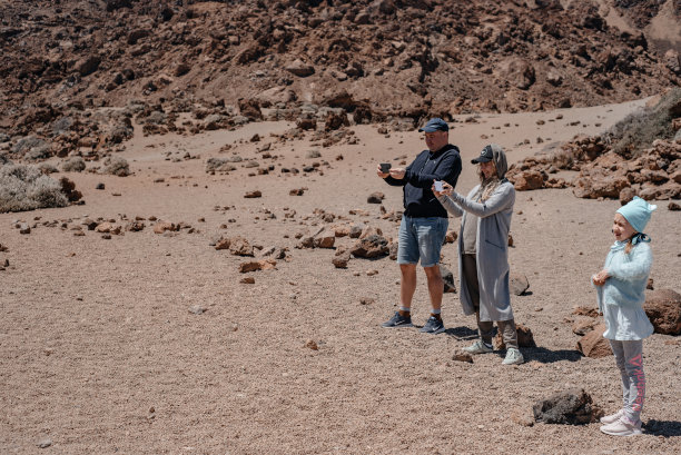 一对夫妇带着孩子在沙漠里拍照。图片下载
