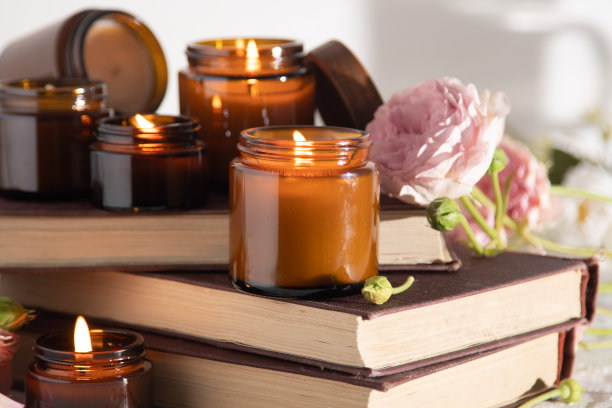 一套不同的香薰蜡烛放在棕色的玻璃罐里。有香味的手工蜡烛。大豆蜡烛在罐子里燃烧。芳香疗法和放松在水疗中心和家庭。仍然生活。棕色罐子里的火图片下载